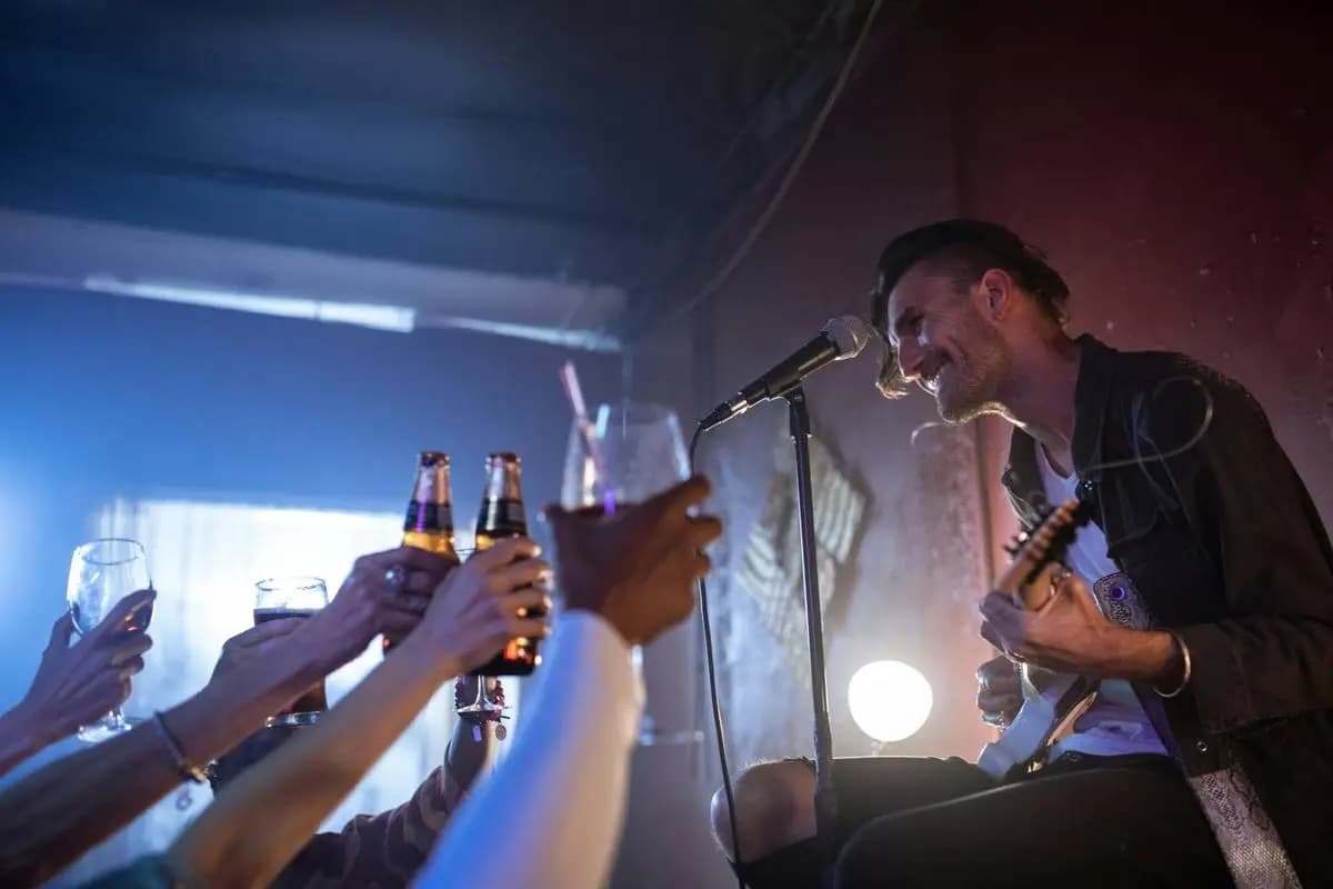 Illustrative photo of a musician and audience; not the scheduled artist or event
