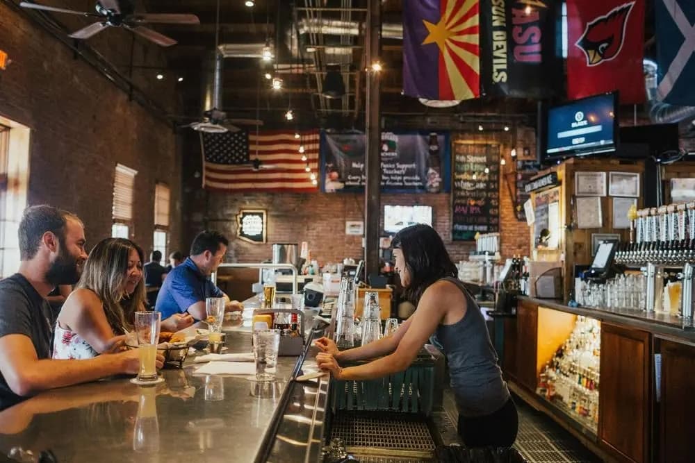 Friends sharing food and drinks at a warmly lit neighborhood bar